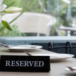 Mesa de restaurante con cartel de reservado en inglés
